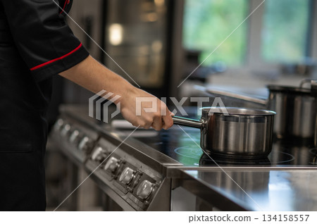 Unrecognizable chef working in restaurant kitchen Unrecognizable chef working in restaurant kitchen 134158557