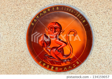 A relief sign with a monkey symbol and Chinese characters is placed on a wall in Nanshan Park, Sanya 134159057