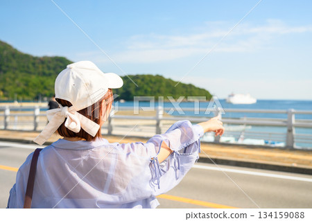 一名女子指著港口的大海。 134159088