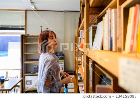Choosing a book at a general store 134159093