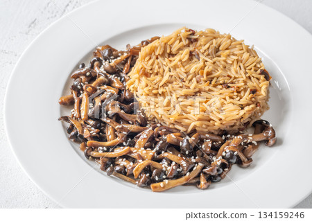 Savory fried rice topped with umami Shimeji mushrooms and golden sunny egg Savory fried rice topped with umami Shimeji mushrooms and golden sunny egg 134159246