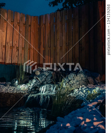 An alpine slide on the terrace of a country house. Nearby is a pond and a wooden fence. 134159268