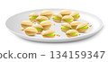 Pistachios on a white porcelain plate isolated on white background. Natural organic food. Realistic nuts. pistachio kernels are ripe and tasty, a source of protein. 3d vector illustration. 134159347