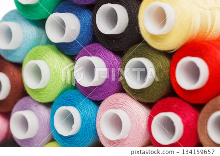 multi-colored spools of sewing thread on a white background 134159657
