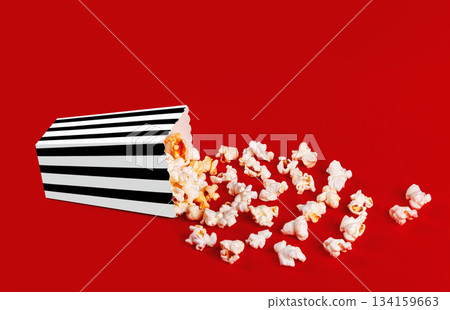 box with popcorn striped in different colors on a red background 134159663