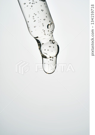 Cosmetic pipette dispensing serum creating bubble close-up Cosmetic pipette dispensing serum creating bubble close-up 134159718