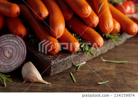 Smoked sausages with tomatoes, onion, garlic, and rosemary. 134159974