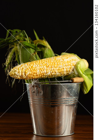 fresh corn cob with husk on black background 134160102