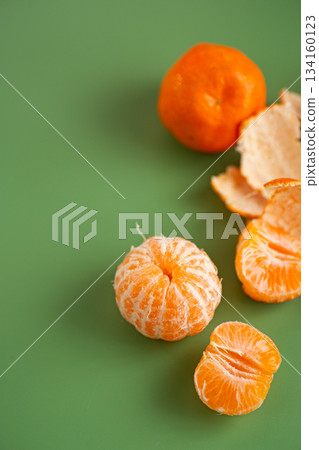 Bright juicy mandarin fruits arranged with natural citrus peel Bright juicy mandarin fruits arranged with natural citrus peel 134160123