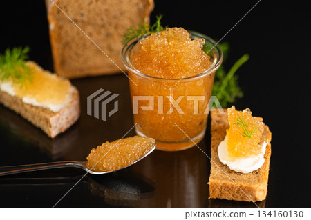 Luxurious fish roe appetizer presented in refined dark studio setting Luxurious fish roe appetizer presented in refined dark studio setting 134160130