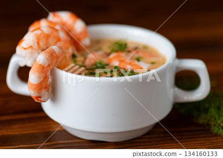 Creamy shrimp soup served warmly with fresh herbs garnish Creamy shrimp soup served warmly with fresh herbs garnish 134160133