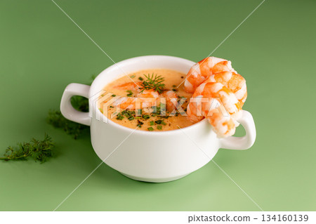 Traditional creamy shrimp soup served warm with aromatic seasoning and garnish 134160139