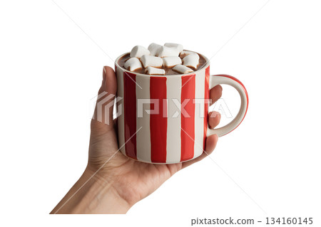 Hand holding warm, striped ceramic mug filled with hot chocolate and topped with fluffy marshmallows, cozy comfort drink 134160145