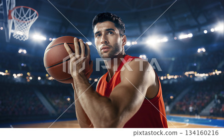 Basketball player prepares to shoot during a game in a large arena with bright lights 134160216