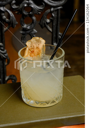 A refreshing citrus drink in a glass with a straw 134162064