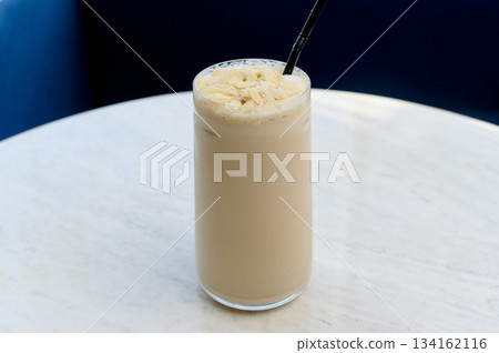 Tall glass of iced latte with almond flakes Tall glass of iced latte with almond flakes 134162116
