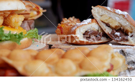 Tasty burger image, Juicy sandwich filled with toppings, Appetizing picture of juicy burger with fresh ingredients, Highresolution image showcasing delectable burger with all savory toppings visible 134162450