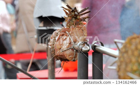 Charcoalgrilled pork with pineapple, Barbecued pork and pineapple skewers on smoky charcoal grill, Vendor preparing grilled pork skewers with pineapple slices over wood charcoal fire for customers 134162466