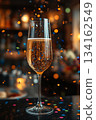 Glass of champagne on table with confetti is various colors and sizes, creating festive and celebratory atmosphere 134162549