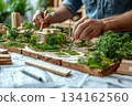 Man is drawing a model of a city with a brush 134162560