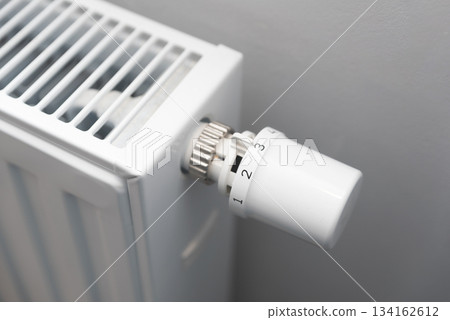 Person is adjusting the temperature on a radiator Person is adjusting the temperature on a radiator 134162612