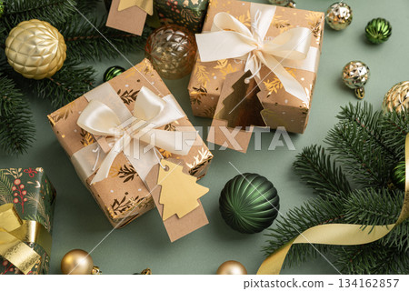 Christmas Gifts with Ornaments and Evergreen Branches on Festive Background 134162857