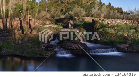 Small waterfalls in a mountain stream on a sunny day Small waterfalls in a mountain stream on a sunny day 134164019