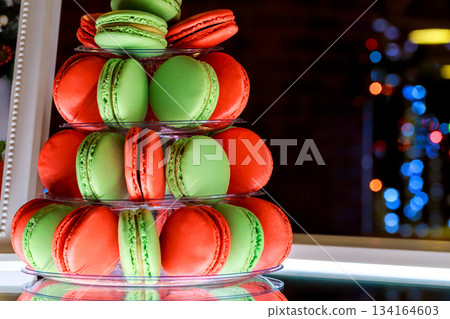 Colorful macaron display at festive event sweet treats on clear stand Colorful macaron display at festive event sweet treats on clear stand 134164603
