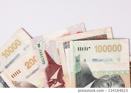 Different types of banknotes stacked on a flat surface showing various denominations and designs in a simple arrangement 134164623