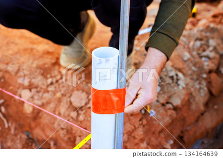 Workers measure mark location of pipe during construction in building site 134164639