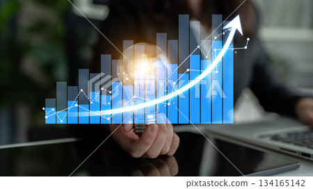 Business Growth and Success Concept with Person Holding Light Bulb, Abstract Financial Graphs, Positive Trends, and Bright Ideas for Improvement Scalp 134165142
