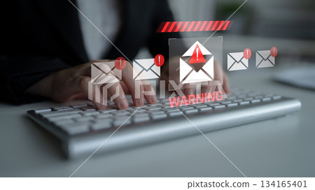 Warning notification on a laptop screen indicating potential email threats with hands typing on a keyboard in a blurred background Gantry Warning notification on a laptop screen indicating potential email threats with hands typing on a keyboard in a blurred background Gantry 134165401
