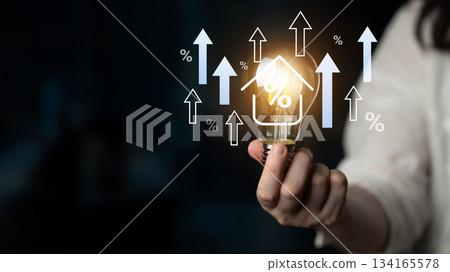 Concept of home energy savings and efficiency represented by a light bulb and upward arrows indicating growth in savings and reductions in costs Gantry Concept of home energy savings and efficiency represented by a light bulb and upward arrows indicating growth in savings and reductions in costs Gantry 134165578