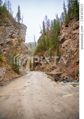 Red Gates canyon entrance on gravel road in Altai Russia. Natural rock formation gateway between cliffs Red Gates canyon entrance on gravel road in Altai Russia. Natural rock formation gateway between cliffs 134165623