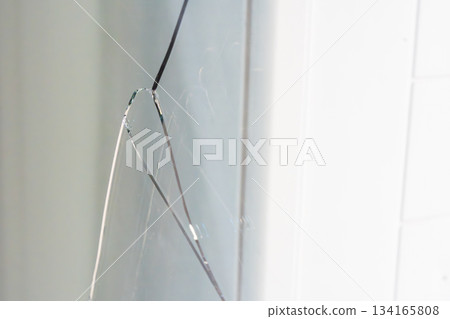Large crack across a triple glazed window in a residential apartment. Indicates potential structural issues, thermal stress or manufacturing defect during construction. 134165808