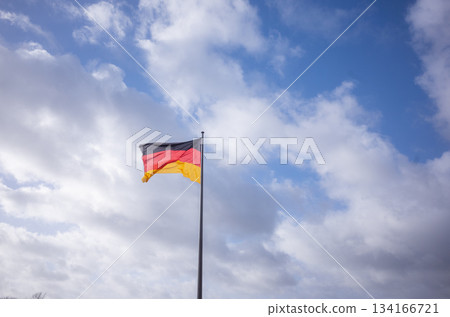 [Germany] The German flag waving in the cloudy sky of the capital Berlin 134166721