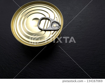 Tin Can With a Key on Dark Surface Ready to Be Opened in Kitchen Setting During Daylight Hours Tin Can With a Key on Dark Surface Ready to Be Opened in Kitchen Setting During Daylight Hours 134167069