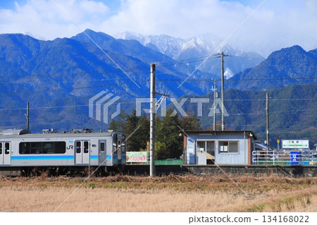 Oito Line E127 series train departing Hosono Station, watched over by the magnificent Northern Alps mountains. Photo taken on December 7, 2025. Oito Line E127 series train departing Hosono Station, watched over by the magnificent Northern Alps mountains. Photo taken on December 7, 2025. 134168022