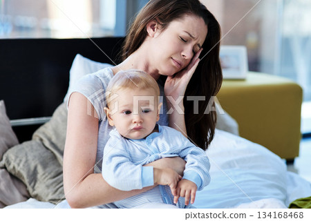 Tired, sick and a mother with a child and headache from parenting stress, burnout and sad. Fatigue, mental health and a mom with postpartum depression, anxiety or pain with a newborn at home 134168468