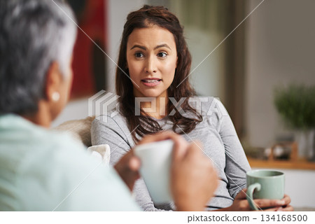 Gossip, coffee and mother with daughter on sofa in living room for bonding, conversation and happiness. Relax, chat and discussion with women talking in family home for generations, reunion and break 134168500