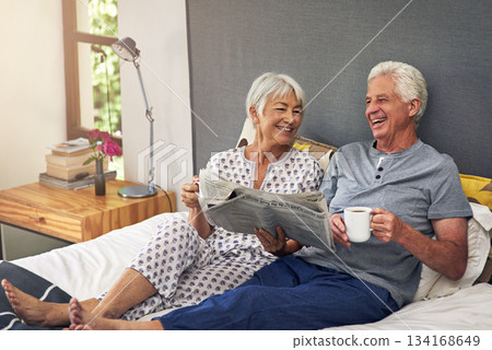 Coffee, newspaper and a mature couple in the bedroom, enjoying retirement in their home in the morning. Tea, reading or love with a happy senior man and woman in bed together to relax while bonding Coffee, newspaper and a mature couple in the bedroom, enjoying retirement in their home in the morning. Tea, reading or love with a happy senior man and woman in bed together to relax while bonding 134168649