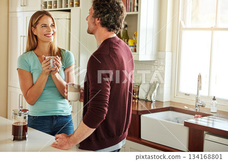 Chat, coffee or happy couple talking in a kitchen at home bonding or enjoying quality morning time together. Love, smile or mature man laughing, relaxing and drinking espresso tea with woman at home 134168801