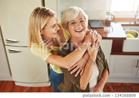 Hug, woman or portrait of mother laughing in kitchen in bonding together with love at home in Italy. Happy family, embrace or adult child hugging a funny senior mom in house cooking lunch or dinner 134168809