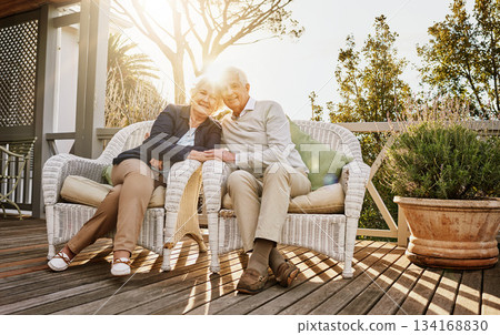 Love, patio and portrait of senior couple with sunrise enjoying bonding, quality time and relax in morning. Marriage, retirement home and elderly man and woman smile with drink for breakfast on deck 134168830