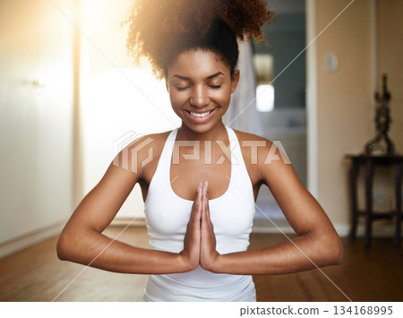 Happy woman, hands and yoga in namaste for meditation, spiritual wellness or zen workout at home. Calm African female yogi smile with hand together in mediate for health, mind and fitness exercise Happy woman, hands and yoga in namaste for meditation, spiritual wellness or zen workout at home. Calm African female yogi smile with hand together in mediate for health, mind and fitness exercise 134168995
