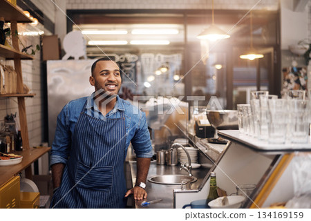 Coffee shop, barista and happy man in cafe for service, working and thinking in restaurant. Small business owner, entrepreneur startup and male bistro waiter smile by cafeteria counter ready to serve Coffee shop, barista and happy man in cafe for service, working and thinking in restaurant. Small business owner, entrepreneur startup and male bistro waiter smile by cafeteria counter ready to serve 134169159