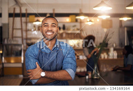 Coffee shop, crossed arms and portrait of black man in restaurant for service, working and happy in cafe. Small business owner, bistro startup and confident male waiter in cafeteria ready to serve 134169164