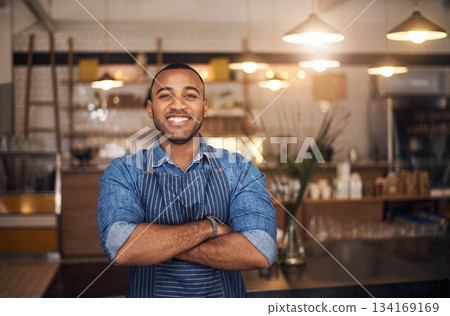 Coffee shop, waiter and portrait of African man in restaurant for service, working and crossed arms in cafe. Small business owner, bistro startup and male barista smile in cafeteria ready to serve 134169169