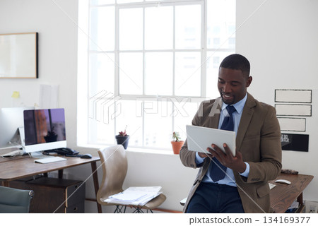 Business, black man and tablet in office for planning, connection and internet research in agency. Happy male worker, digital technology and scroll website for online information, insight and app 134169377