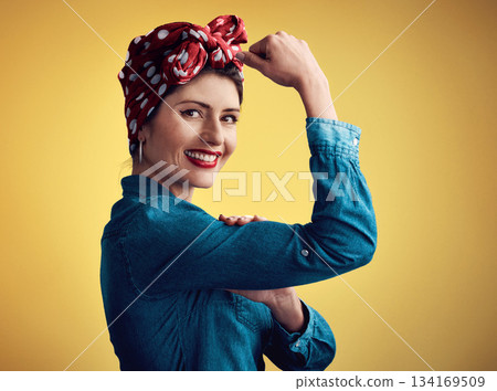 Strong, pinup girl and flexing muscle portrait in studio for beauty, women power and fashion. Happy female person show bicep on yellow background for motivation, freedom and retro or vintage style Strong, pinup girl and flexing muscle portrait in studio for beauty, women power and fashion. Happy female person show bicep on yellow background for motivation, freedom and retro or vintage style 134169509